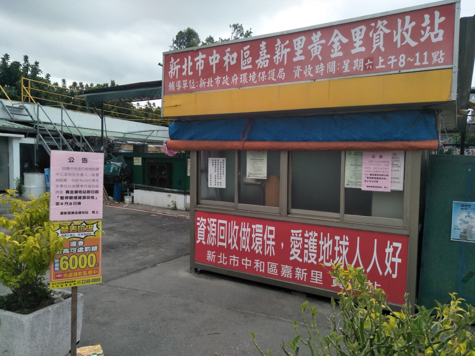 A recycling station closed, with the notice posted on it. Three years of the pandemic left more than case numbers: it left paper everywhere — notices, signs, routing instructions — redrawing daily life square by square.