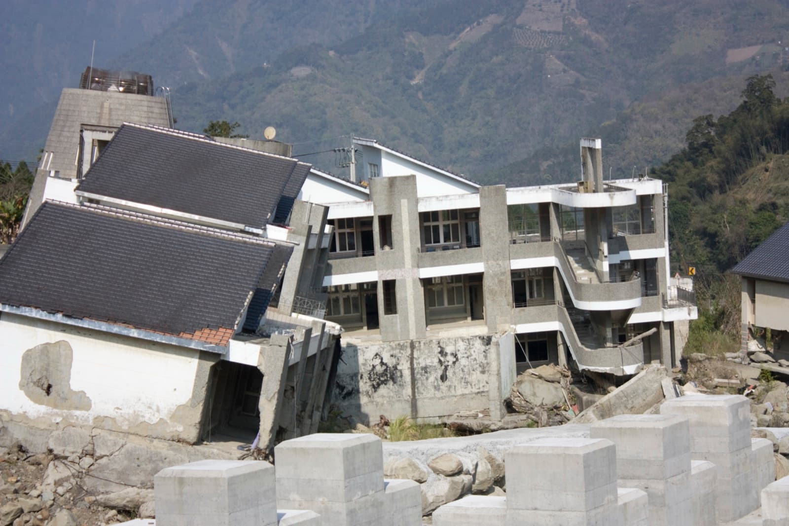 The old buildings of Longhua Elementary, left where the landslide shoved them. Morakot took out roads, bridges and whole villages in the southern mountains; Xiaolin was buried by a single collapse before dawn on 9 August.