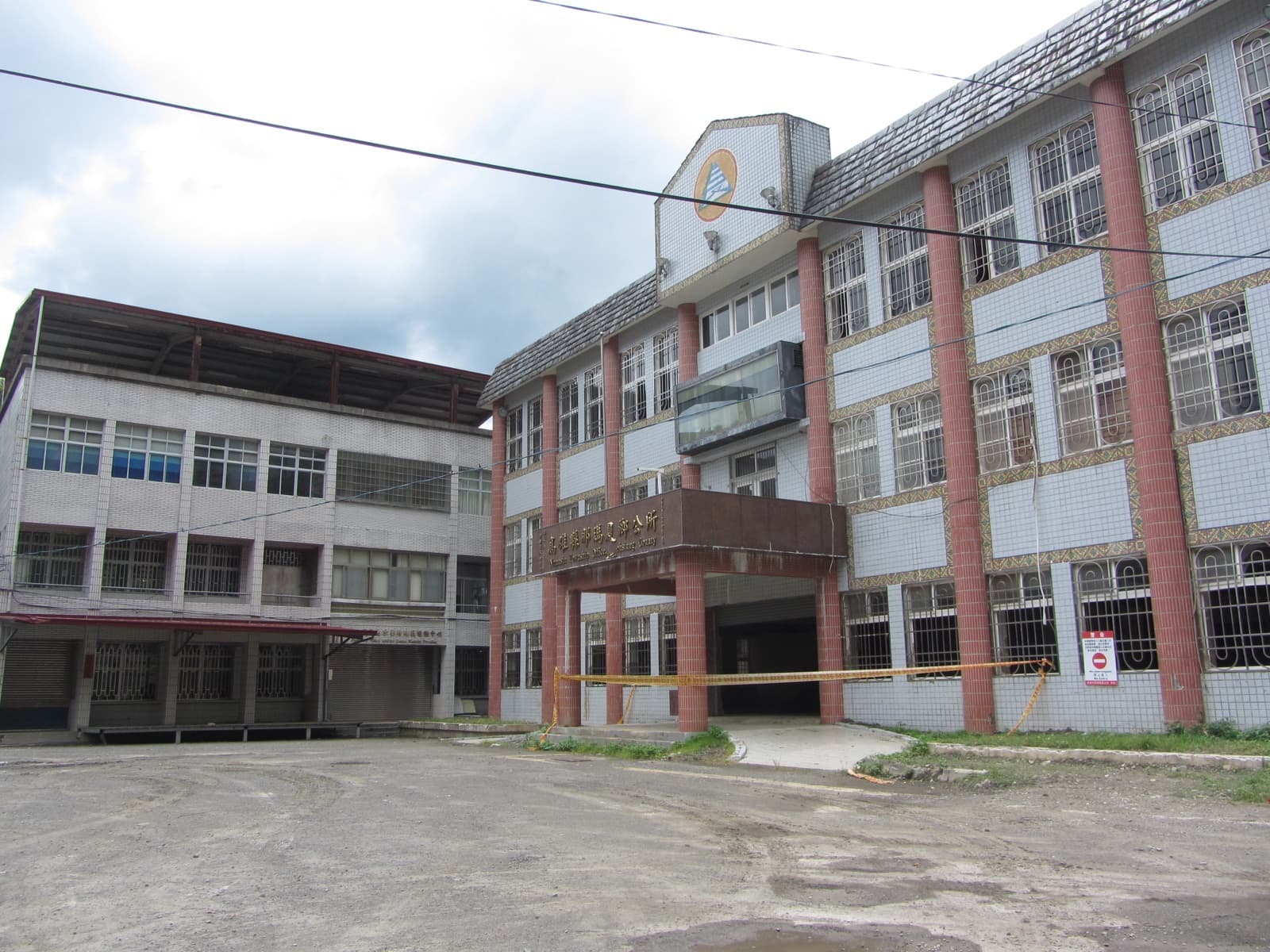 The Namasia township office after the flood. Reconstruction moved several communities down to permanent housing on the plain, and left a question nobody has settled: once you are off the mountain, is it still the same community.