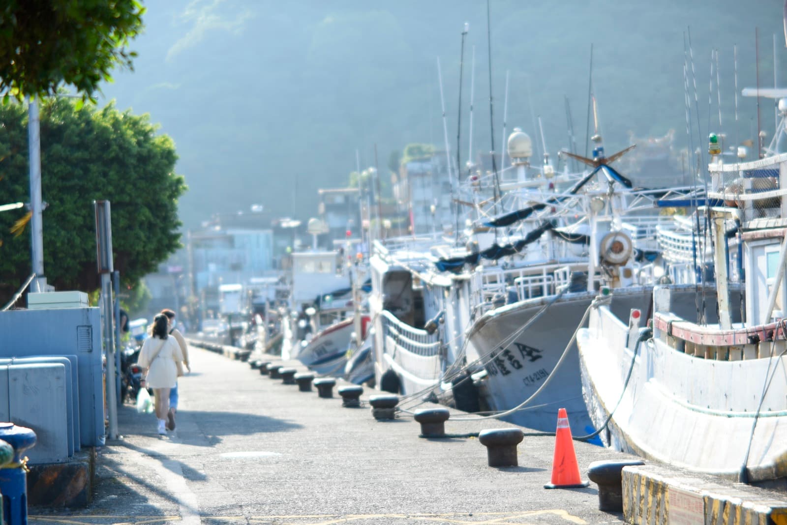 Nanfang'ao fishing port on 1 October 2022, three years to the day after the bridge fell. The boats are moored hull against hull along the quay, and for many foreign fishermen the bunks aboard were where they lived.
