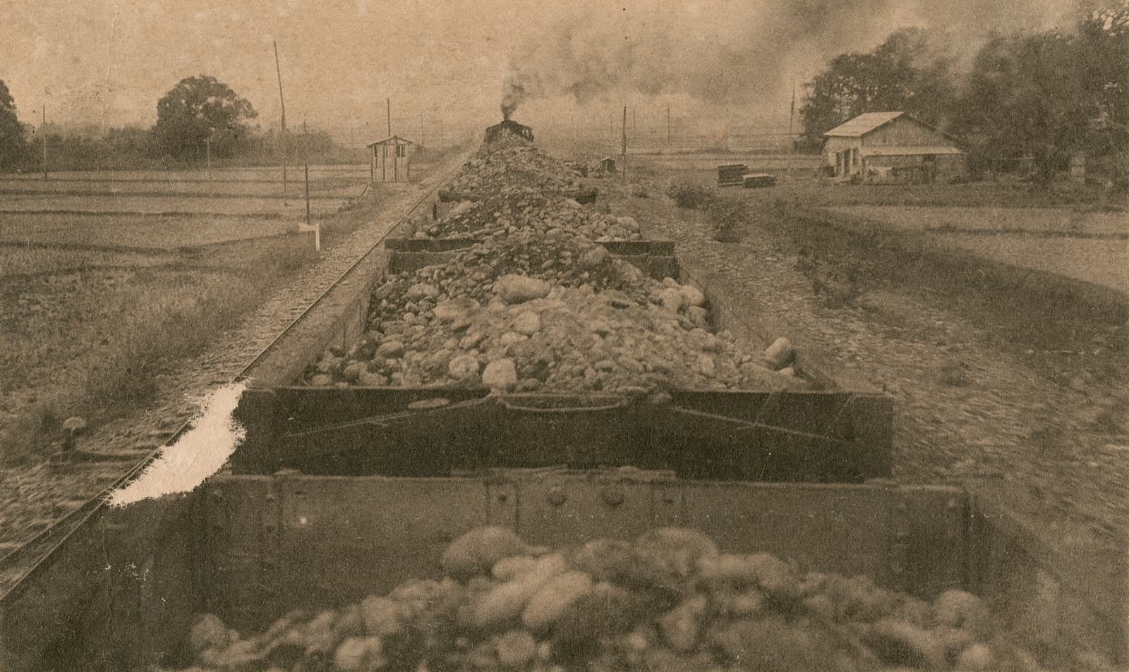 A train hauling gravel to the Wushantou dam site. Hatta Yoichi chose semi-hydraulic fill, sluicing earth and rock into place — a method without precedent in East Asia at the time.